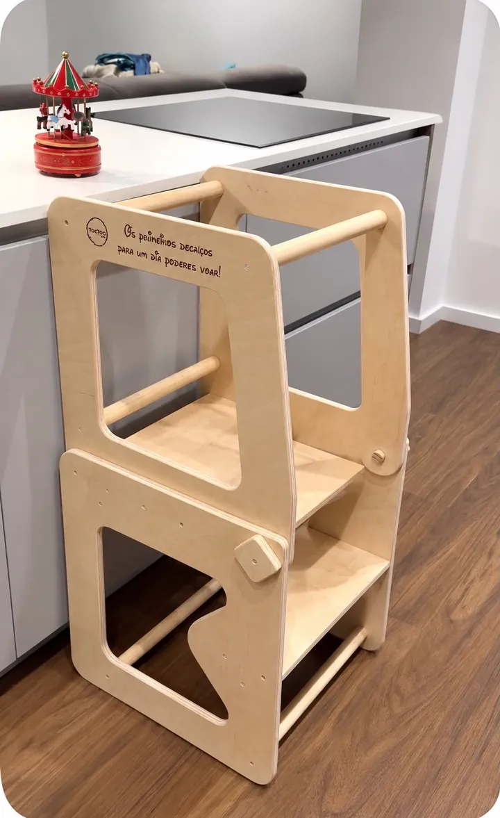 Torre/mesa de aprendizagem junto à bancada de uma cozinha, com uma frase gravada